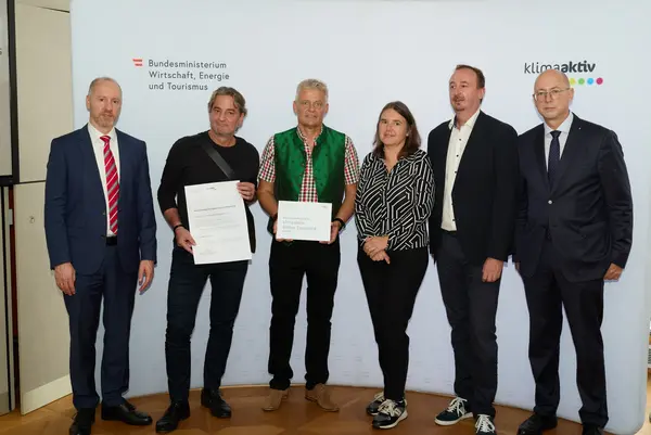 6 Personen mit Urkunde schauen in die Kamera