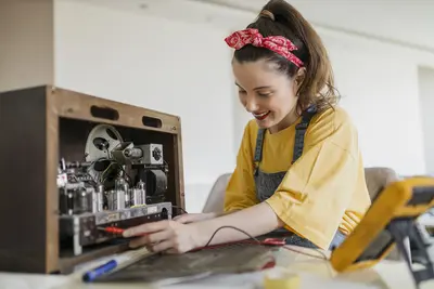 Eine Frau repariert ein altes Radio.