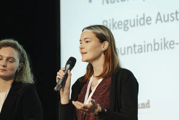 Frau mit Mikro am Podium