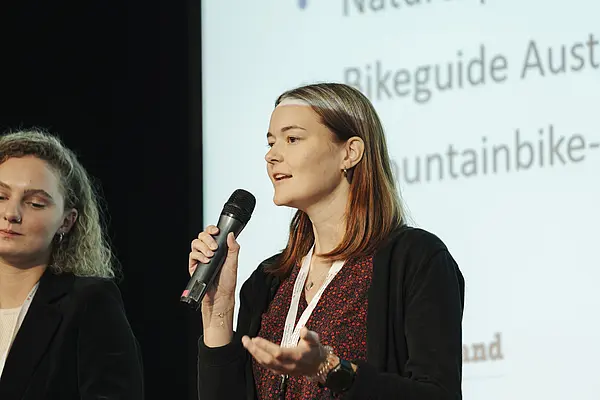 Frau mit Mikro am Podium