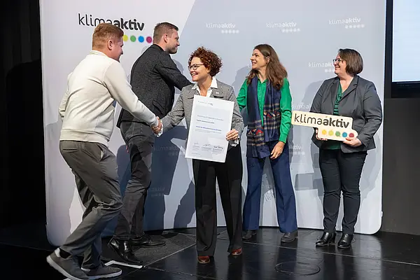 Menschen auf einer Bühne schütteln Hände, gratulieren sich