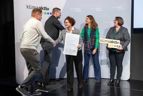 Menschen auf einer Bühne schütteln Hände, gratulieren sich