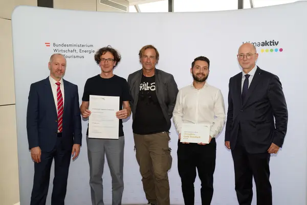 5 Personen mit Urkunde schauen in die Kamera