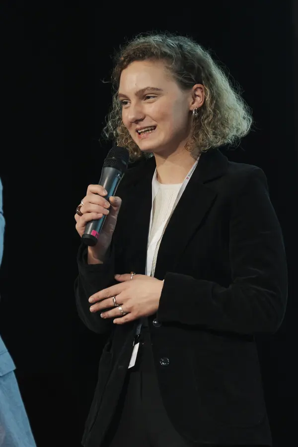 Frau mit Mikro am Podium