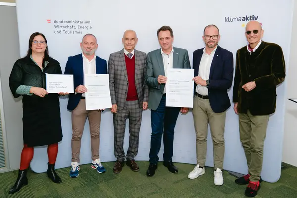 Personen mit Urkunden schauen in die Kamera