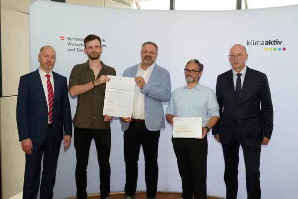 5 Personen mit Urkunde schauen in die Kamera