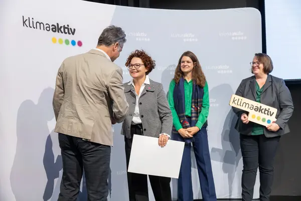 Menschen auf einer Bühne schütteln Hände, gratulieren sich