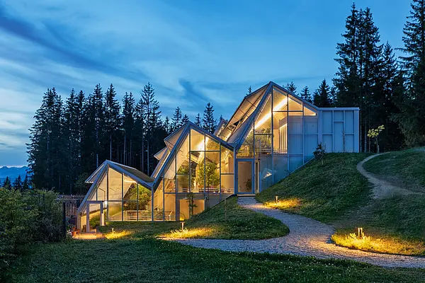 Das Glashaus des Restaurants von außen bei Nacht.