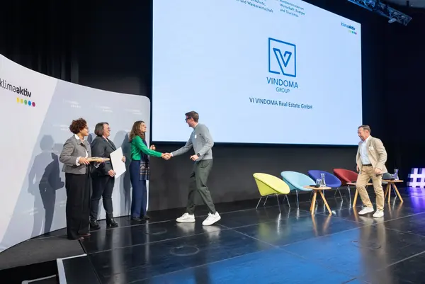 Personen auf einer Bühne gratulieren sich, schütteln Hände