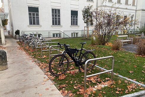 Radabstellanlagen mit Anlehnbügel neben Gehweg auf grüner Wiese
