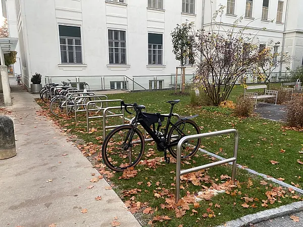 Radabstellanlagen mit Anlehnbügel neben Gehweg auf grüner Wiese
