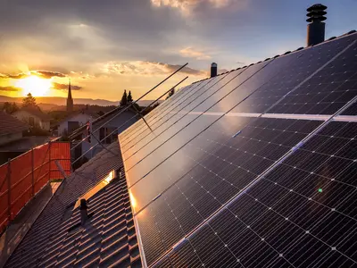 PV-Panele am Dach leuchten im Sonnenuntergangslicht