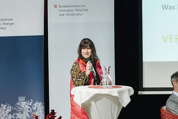 Frau am Podium spricht mit Mikro