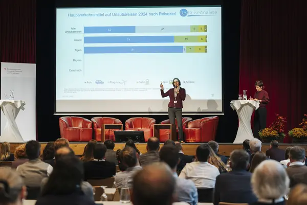 Person präsentiert vor Publikum eine Statistik