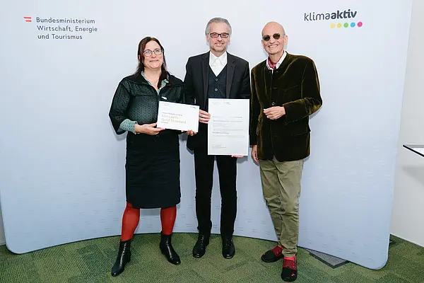 Personen mit Urkunden schauen in die Kamera