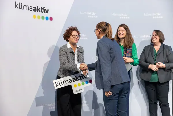 Personen auf einer Bühne gratulieren sich, schütteln Hände