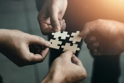Menschen setzen vier Puzzle Teile zusammen