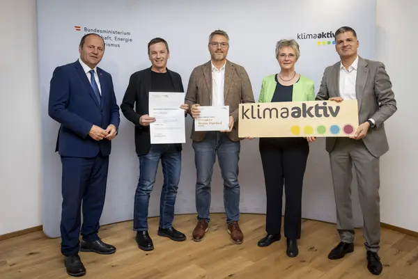 mehrere Personen mit Urkunde in der Hand schauen in die Kamera