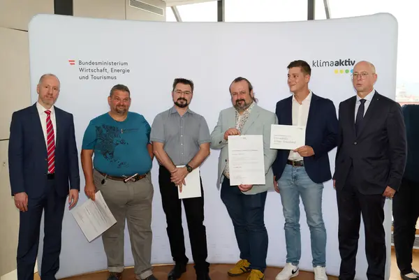 6 Personen mit Urkunde schauen in die Kamera