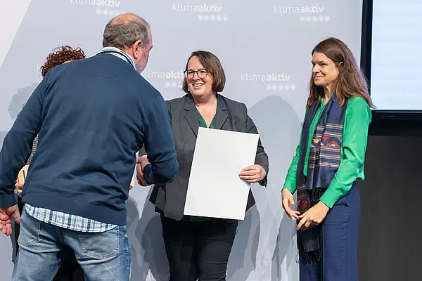 Personen auf einer Bühne gratulieren sich, schütteln Hände