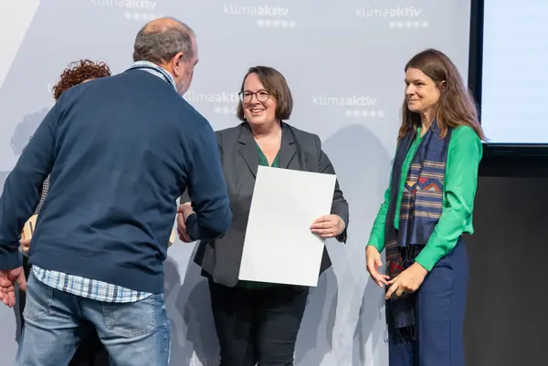 Personen auf einer Bühne gratulieren sich, schütteln Hände