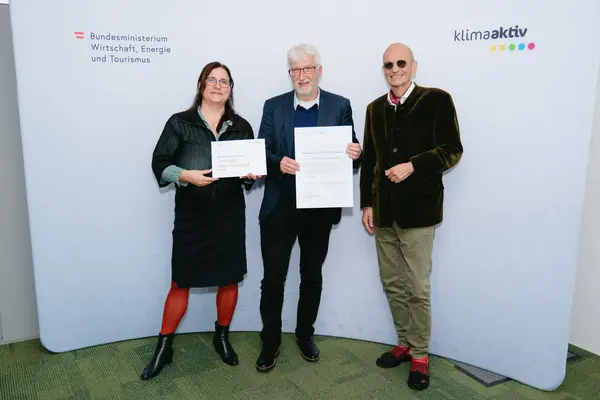 Personen mit Urkunden schauen in die Kamera