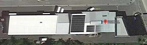 Luftaufnahme eines Firmengebäudes mit Solaranlage auf dem Dach und markiertem Standort ‚Stanzl Service & Elektrotechnik