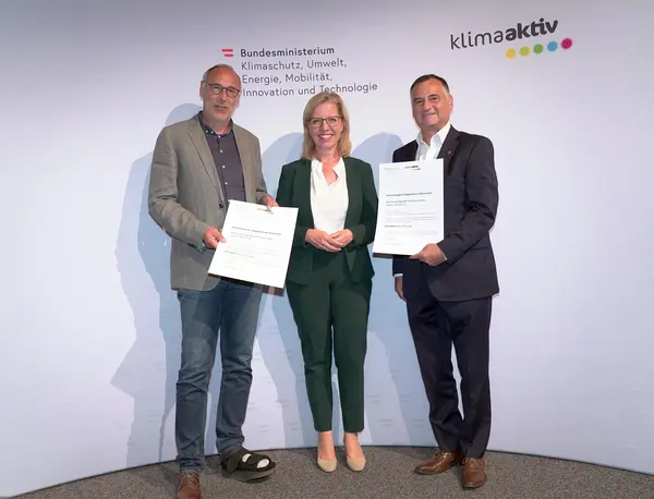 Im Bild: Klimaschutzministerin Leonore Gewessler, Vorstand Helmut Kusternik (meine heimat Gemeinnützige Bau-, Wohn- und Siedlungsgenossenschaft mbH), Roland Omann (Architekten Falle & Omann)