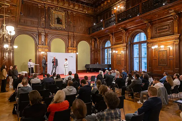 Menschen auf einer Bühne bei einer Veranstaltung mit Publikum
