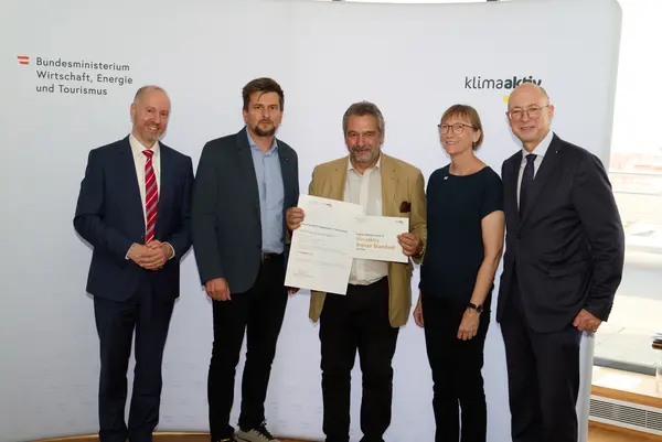 Auszeichnung klimaaktiv Gebäude aus der Steiermark 5 Personen mit Urkunde schauen in die Kamera