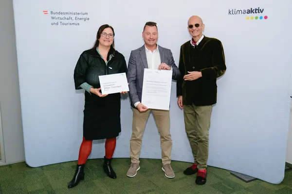 Personen mit Urkunden schauen in die Kamera