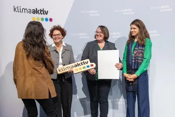 Personen auf einer Bühne gratulieren sich, schütteln Hände