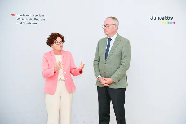 ein Mann und eine Frau auf einer Bühne vor einer Logowand klimaaktiv und BMWET