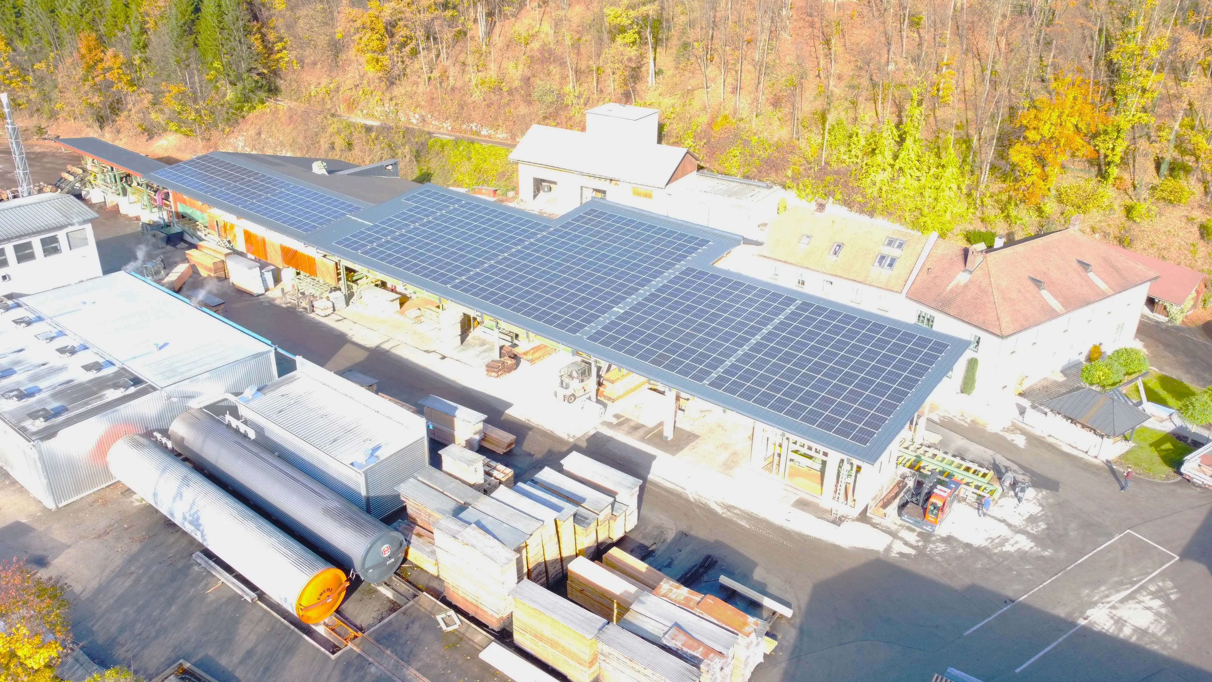 Luftaufnahme von Gebäuden des Holzverarbeitungsbetriebs mit Solarpaneelen auf den Dächern.