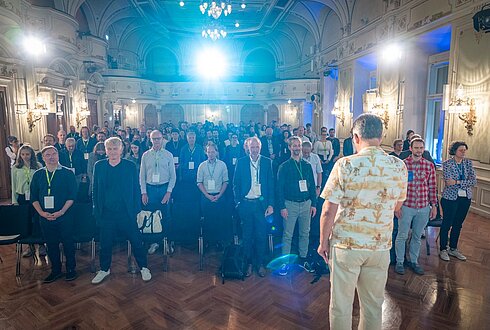 Ein Saal voller Menschen mit geschlossenen Augen