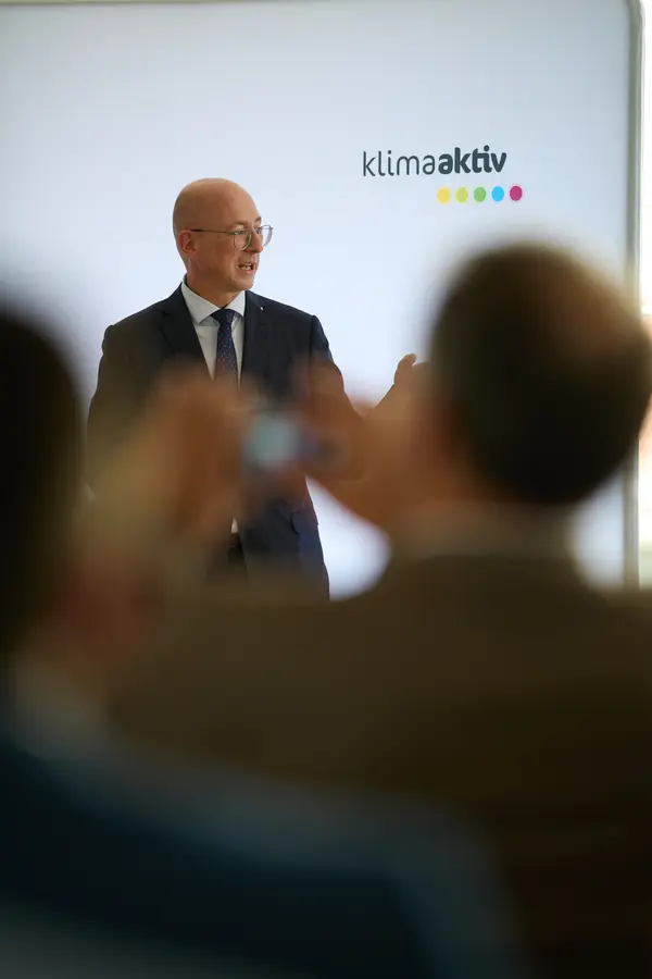 ein Mann im Anzug spricht vor einem Publikum