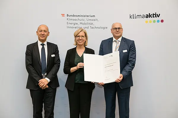 Auszeichnung von klimaaktiv Vorzeigebetrieb B&R Industrial Automation GmbH durch Klimaschutzministerin Leonore Gewessler (BMK). Im Bild: Robert Perperschlager (Global Operations Development Manager) (rechts), Franz Baischer (Health, Safety and Environment - Sustainability Specialist) (links) mit Klimaschutzministerin Leonore Gewessler (BMK) (mitte)