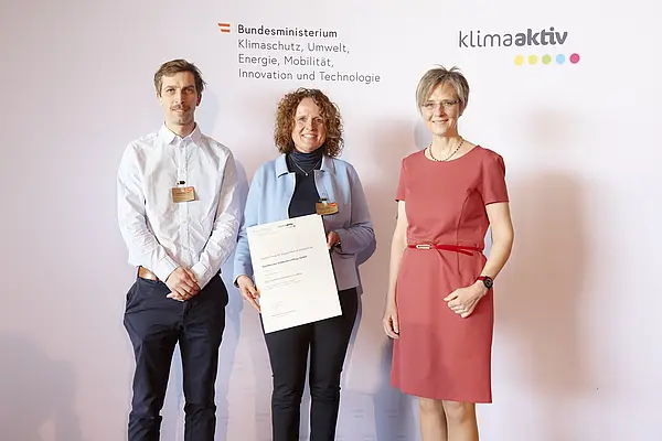 DI Dr. Bettina Bergauer, Stellvertretung Stabsstelle Dialog zu Energiewende und Klimaschutz, zeichnete am 24. März 2022 energieeffiziente Betriebe und Beratungsunternehmen aus.  Ausgezeichneter Betrieb: Barmherzige Schwestern Pflege GmbH  Im Bild: Roland Gumpoltsberger (Umwelt- u. Energiemanager, SANTESIS technisches Gebäudemanagement & Service GmbH), Jana Bockhold (Geschäftsführerin) mit Bettina Bergauer (BMK)
