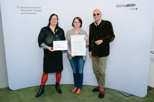 Personen mit Urkunden schauen in die Kamera