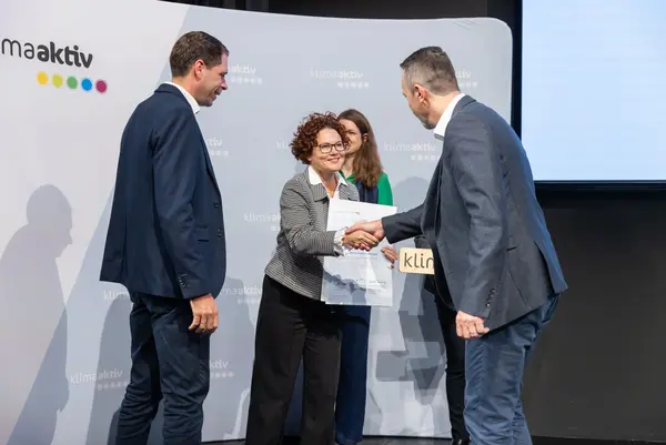 Menschen auf einer Bühne schütteln Hände, gratulieren sich