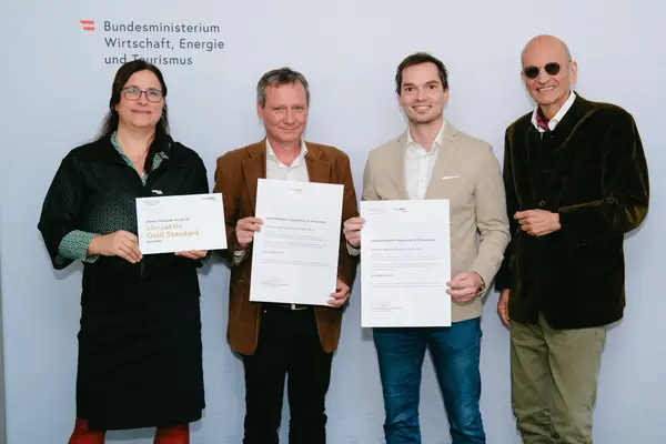 Personen mit Urkunden schauen in die Kamera