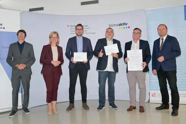 Im Bild: Klimaschutzministerin Leonore Gewessler, LHStv. Josef Geisler, DI Robert Taunmüller (Energie Tirol), Mag. DI Markus Pollo und DI Harald Konrad Malzer (NEUE HEIMAT TIROL, Gemeinnützige WohnungsGmbH), Robert Waldner (FIBY ZT GmbH)