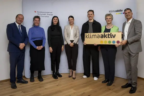 mehrere Personen mit Urkunde in der Hand schauen in die Kamera