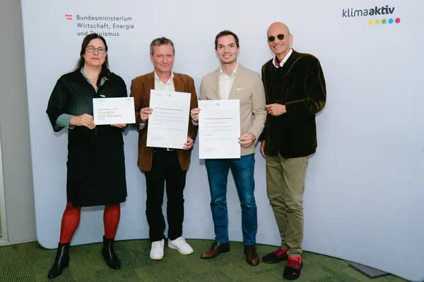 Personen mit Urkunden schauen in die Kamera