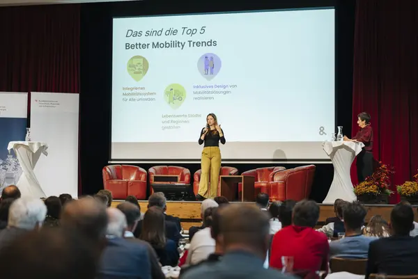 Frau hält Vortrag vor Publikum auf der Bühne