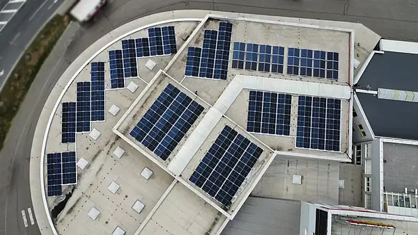 Luftaufnahme mit Blick auf das von der Logmedia GmbH gepachtete Dach. Es sind zahlreiche regelmäßig angeordnete PV-Paneele auf unterschiedlichen Dachbereichen zu erkennen.