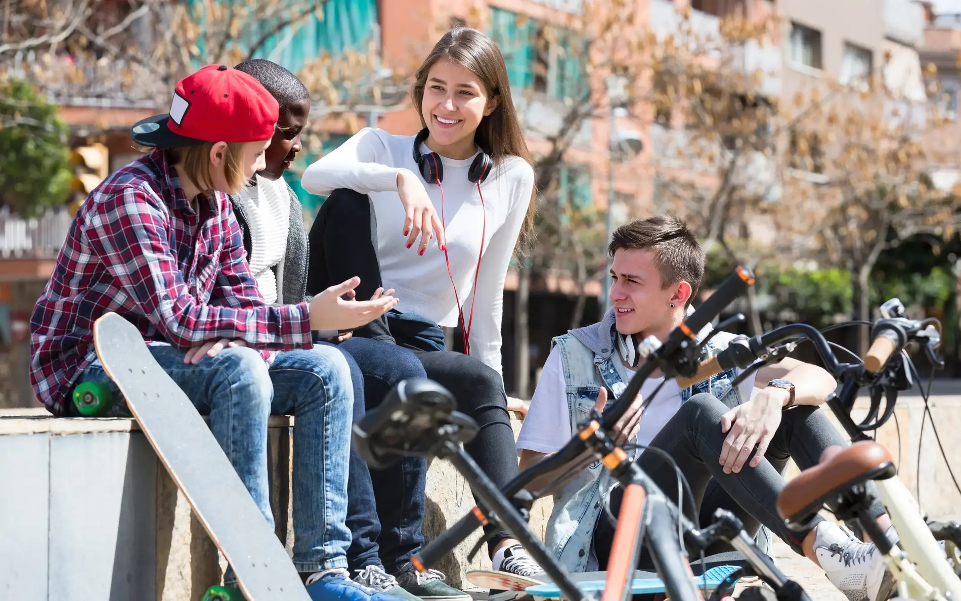 Jugendliche sitzen zusammen und reden miteinander. Vor ihnen lehnen ihre Fahrräder.