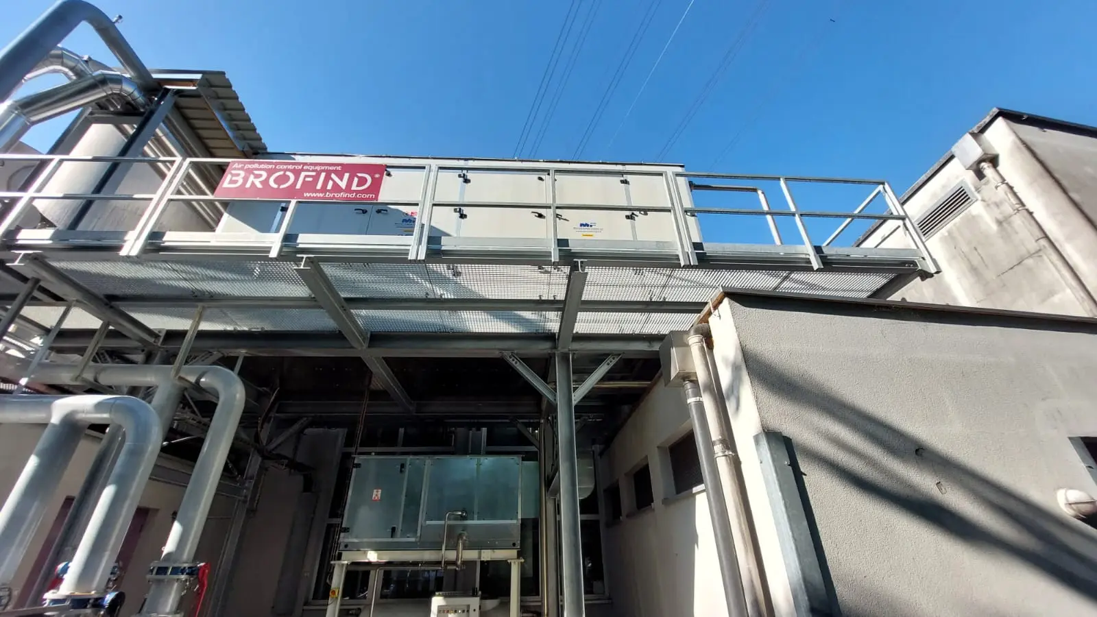 Industrieanlage mit Ammoniak-Kühlsystem, Wäscher und Rohrleitungen unter freiem Himmel.