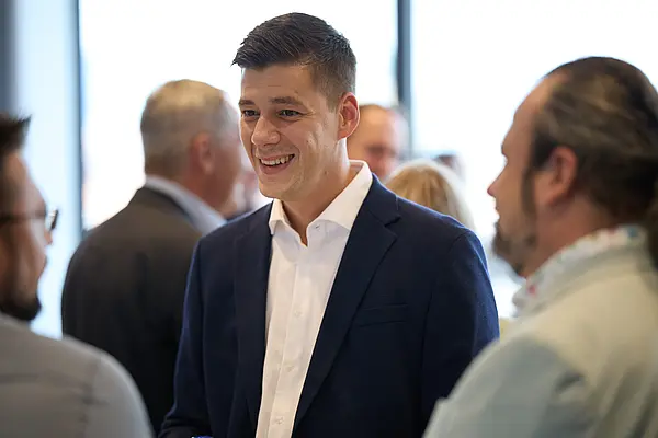 Besucher:innen einer Veranstaltung unterhalten sich