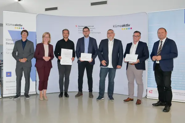 Im Bild: Klimaschutzministerin Leonore Gewessler, LHStv. Josef Geisler, DI Robert Taunmüller (Energie Tirol), Mag. DI Markus Pollo und DI Harald Konrad Malzer (NEUE HEIMAT TIROL, Gemeinnützige WohnungsGmbH), Arch. DI Michael Schafferer (Schafferer Architektur), Robert Waldner (FIBY ZT GmbH)